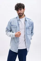 Sobrecamisa de jean de hombre, color azul claro con efecto acid wash. Posee cuello camisero, cierre frontal de botones y dos bolsillos con tapa en el pecho.