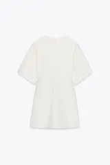 Vestido corto blanco de tejido de punto, con cuello redondo, mangas cortas y cierre trasero con cremallera.