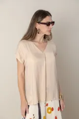 Blusa fucsia de seda con escote en V y mangas cortas.