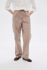Pantalón de algodón color beige, de corte recto y tiro medio, con bolsillos laterales y cintura con cordón ajustable.