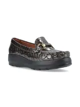Mocasín de cuero charol negro con plataforma blanca y detalle de hebilla metálica plateada en el empeine.