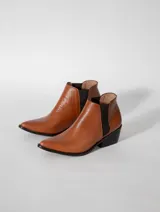 Botines marrones de cuero vacuno, con elástico lateral negro, punta fina y taco cuadrado de 5cm. Hechos en Uruguay.