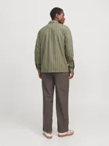 Sobrecamisa de manga larga color verde oliva con rayas verticales finas en tono más claro. Tiene cuello clásico, cierre con botones, dos bolsillos en el pecho con cierre de botón y puños abotonados. Corte recto y cómodo. Confeccionada en tejido de sarga de algodón y lino.