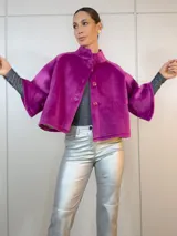 Chaqueta corta fucsia de terciopelo con cuello alto, mangas 3/4 amplias y cierre frontal con botones.