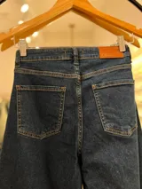 Pantalón de jean azul oscuro, de tiro alto y corte wide leg.