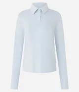 Blusa polo celeste de mangas largas confeccionada en tejido interlock compuesto por algodón BCI.