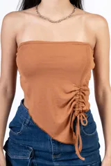 Strapless blanco con frunce lateral y tiras ajustables.