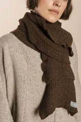 Bufanda tejida color marrón chocolate en punto fantasía con efecto de volado en los bordes.