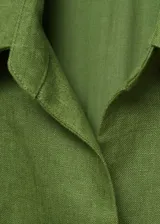 Mono largo color verde oliva, de lino, con cuello camisero, cierre delantero y cinturón trenzado desmontable.
