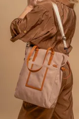 Cartera tipo tote bag color negro, con doble asa de mano y correa bandolera ajustable. Presenta un bolsillo rectangular en el frente.