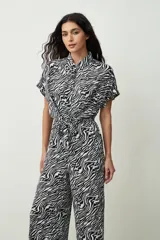 Mono largo negro de corte palazzo con camisa de mangas cortas con botones y lazo en la cintura.