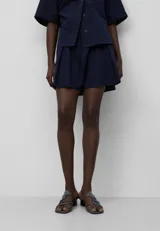 Bermuda corta azul marino de seersucker de algodón con volumen amplio, cintura elástica con cordón, bolsillos laterales y bolsillo de vivo en la espalda.