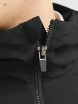 Campera negra liviana con capucha ajustable, cierre frontal con cremallera y bolsillos delanteros con cierre. Puños de canalé.