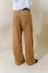 Pantalón de lino rústico color blanco, de calce recto y tiro medio. Tiene bolsillos delanteros y traseros.