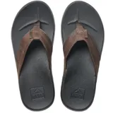 Sandalias Reef Cushion Phantom de hombre, con base negra y tiras marrones de cuero sintético.