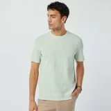 Remera de manga corta color verde claro, con cuello redondo y textura de punto jacquard.