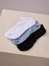 Pack de tres pares de medias de algodón a la altura del tobillo, en color blanco, celeste y negro.