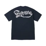 Camiseta azul con el logo de Supreme en el centro de la espalda, realizado con cinta plateada arrugada.