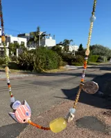 Collar corto de cuentas de colores con dije de pez de cerámica, piedras naturales y detalles en plata 925.