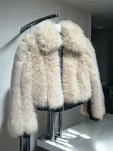 Campera corta de piel sintética color beige con cuello amplio, cierre frontal con cremallera y forro interior.