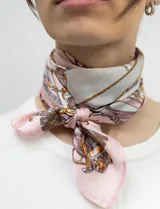 Pañuelo cuadrado de satén con estampado de cadenas doradas y detalles en rosa y blanco.