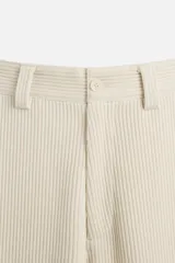 Pantalón largo color beige confeccionado en pana de algodón, de corte wide fit, con bolsillos frontales y traseros.