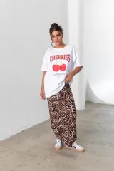 Conjunto que incluye camiseta blanca con estampado de cerezas y pollera larga de viscosa, con diseño animal print.