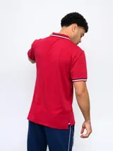 Remera polo azul con cierre, puños y cuello con detalle tricolor. Incluye logo de Umbro y escudo del Club Nacional de Football.