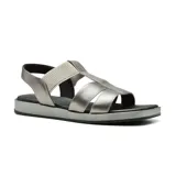 Sandalias bajas de cuero color dorado, con tiras anchas cruzadas en el empeine y pulsera al tobillo con hebilla.