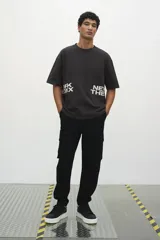 Remera negra de corte holgado con cuello redondo y mangas cortas. Estampado frontal con la inscripción "ORK XON NEW THE".