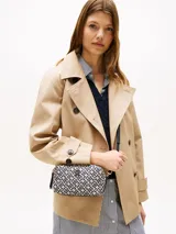 Bandolera Tommy Hilfiger con estampado de monograma TH en jacquard color beige y azul marino. Tiene correa ajustable extraíble, cierre de cremallera y dos compartimentos principales.