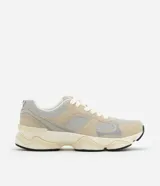 Championes de running color beige y gris con recortes geométricos y suela chunky negra.