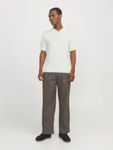 Polo blanco de punto estructurado con fit regular. Cuello polo clásico, mangas cortas y cierre con botones. Tejido con textura sutil.