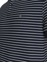 Chomba Tommy Hilfiger de corte regular a rayas horizontales blancas y azul marino, con cuello clásico y tapeta de dos botones. Logo de la marca bordado en el pecho. Confeccionada en tejido técnico elástico que absorbe la humedad y cuenta con propiedades antiolores.