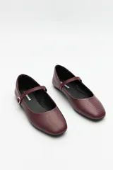 Balerinas color borgoña de cuero sintético texturizado, con tira sobre el empeine y hebilla metálica ajustable.