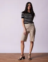 Bermuda color beige en gabardina elastizada, con pretina ancha elastizada, bolsillos simulados en la parte delantera y bolsillos aplicados en la parte trasera.