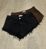 Shorts marrones con tachas, tiro alto y terminación desflecada.