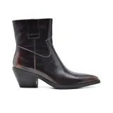 Bota texana de cuero color marrón oscuro con detalles de pespuntes en color cobre. Tiene caña media, punta fina y taco bajo. Elástico en los laterales. Estilo western.