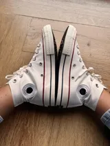 Zapatillas de lona blancas de caña alta con cordones y puntera de goma. Logo de durazno engomado en la base y en la cara interna.
