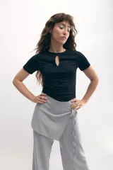 Top negro de jersey elastizado, de manga corta y corte ajustado, con abertura en forma de gota en el escote y frunces verticales en el frente.