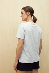 Remera blanca de algodón liviano con textura sutil, manga corta y cuello redondo.