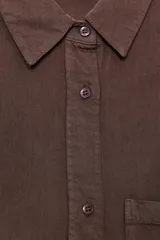 Camisa marrón de manga larga con cuello solapa, bolsillo de parche en el pecho y cierre frontal con botones.