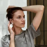 Aros tipo botón dorados con textura irregular que simula la superficie de un molusco.