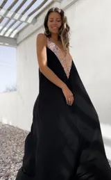 Vestido largo negro con escote en V y apliques de lentejuelas doradas en el corpiño.