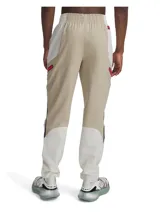 Pantalón cargo Under Armour Unstoppable para hombre, color beige con paneles laterales en marrón claro y detalles en rojo. Confeccionado en tejido técnico resistente al agua, elástico y duradero. Cuenta con bolsillos cargo con cierre y cintura elástica ajustable.