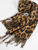 Bufanda rectangular de poliéster con estampado animal print en tonos marrón y negro, con flecos en los extremos.