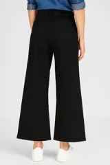 Pantalón de jean color gris oscuro, de corte ancho y tiro alto, con ruedo desflecado.