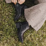 Botas cortas de cuero color marrón con cierre lateral, taco de madera de 5cm y suela de caucho.