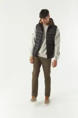 Chaleco inflable verde oliva con capucha ajustable, cierre frontal y bolsillos laterales con cierre.