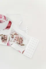 Top tipo corset con estampa floral, confeccionado en tul elástico con estructura interna y copas armadas. Breteles regulables y cierre con triple hilera de broches en espalda.